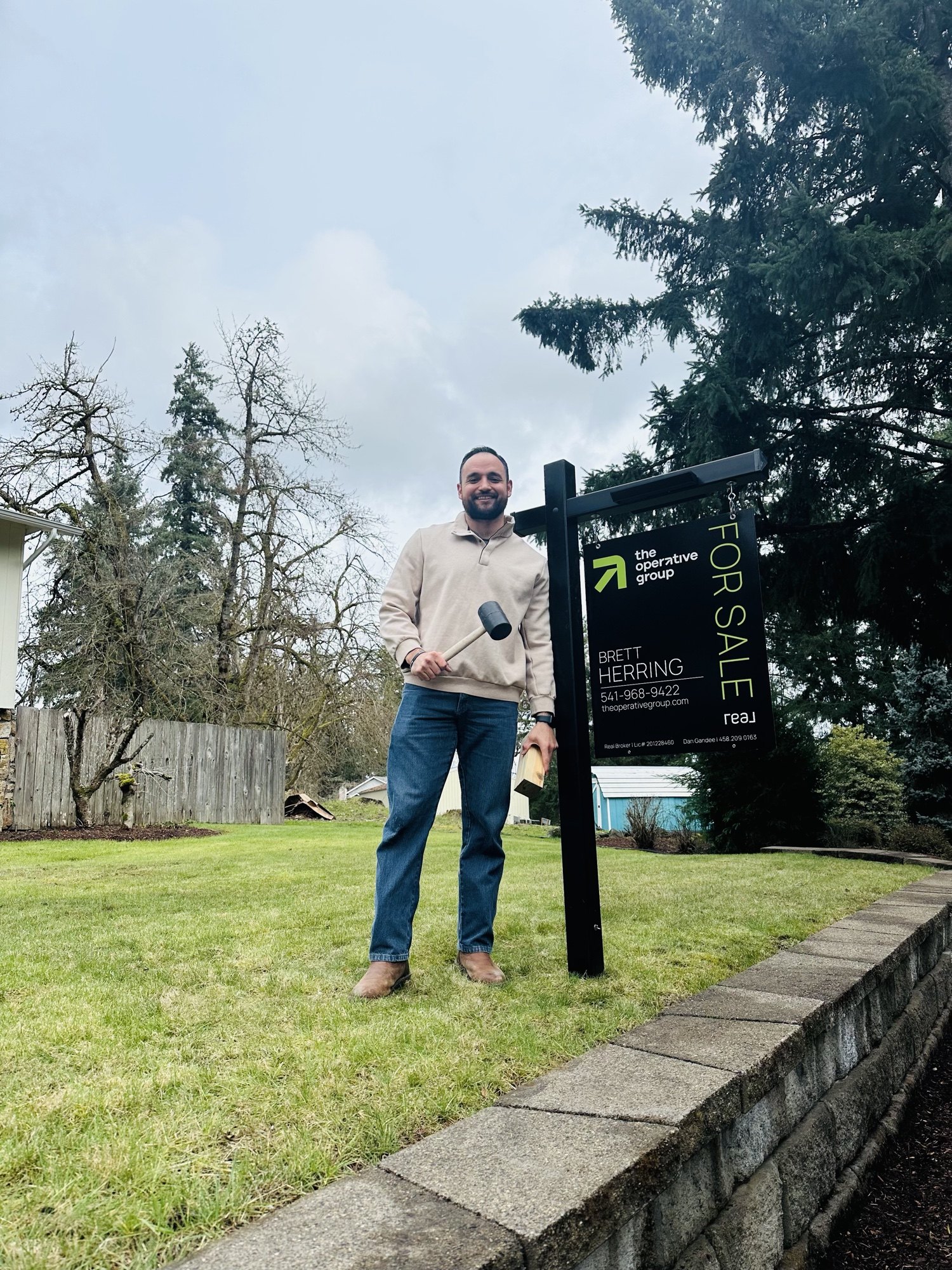 Brett Herring installing a for sale sign at a Lane County, Oregon listing